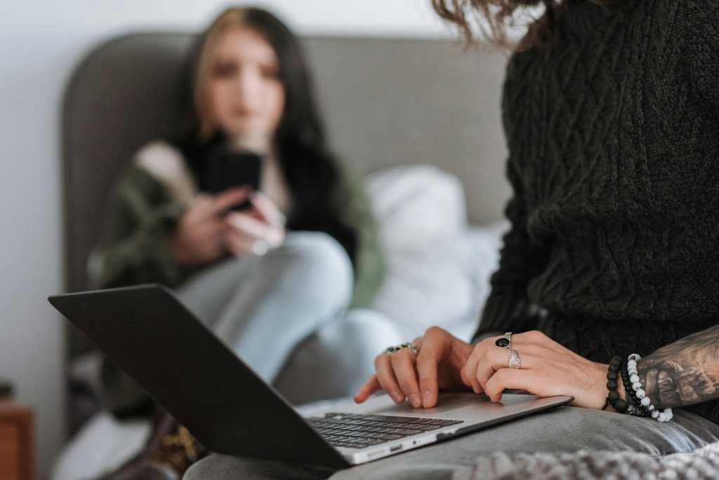 Two woman - one on laptop and one on phone