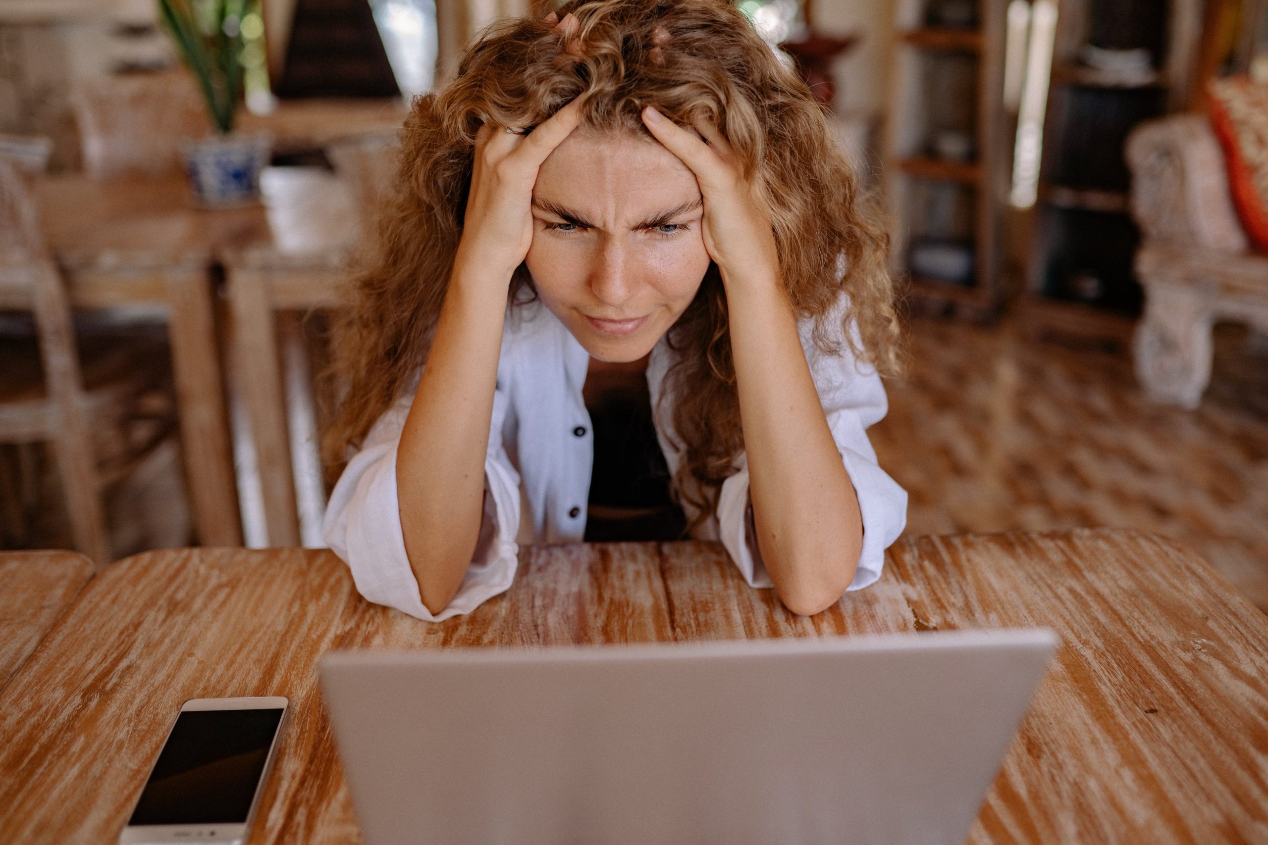 Woman staring at laptop looking distresses